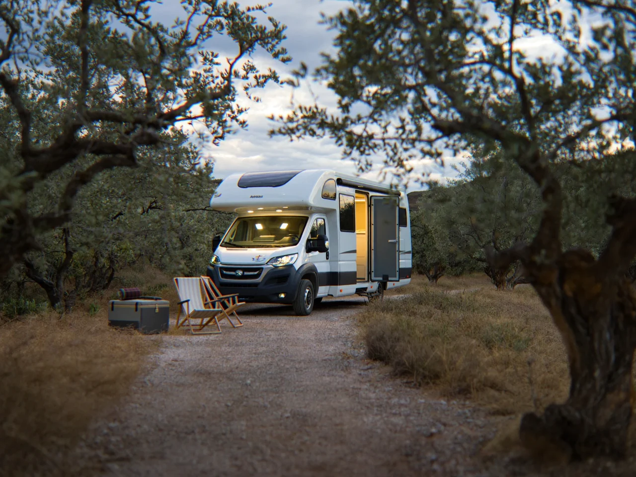 Camper bianco al tramonto su una strada di campagna pugliese tra gli ulivi